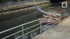 Petugas membersihkan sampah di sepanjang Kali Taman Anggrek, Jakarta, Rabu (8/7/2020). Banyaknya limbah menyebabkan Kali Taman Anggrek menjadi berwarna hitam dan berbau tidak sedap meskipun dibersihkan setiap hari. (Liputan6.com/Immanuel Antonius)