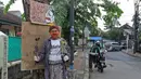 Seniman wayang uwuh, Iskandar Hardjodimuljo menyiapkan paket bahan makanan untuk digantung di jalan Cawang Baru Utara, Jakarta, Sabtu (18/4/2020). Paket yang diberi nama "Wayang Bersedekah" tersebut untuk membantu warga yang kesulitan akibat dampak pandemi covid-19. (Liputan6.com/Herman Zakharia)