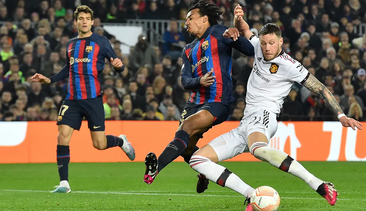 Bek Barcelona Jules Kounde (tengah) berebut bola dengan striker Manchester United (MU)  Wout Weghorst pada leg pertama play-off babak gugur Liga Europa 2022/2023 di Camp Nou, Jumat (17/2/2023) WIB.  MU harus puas menutup laga kontra Barcelona dengan skor 2-2. (Pau BARRENA / AFP)
