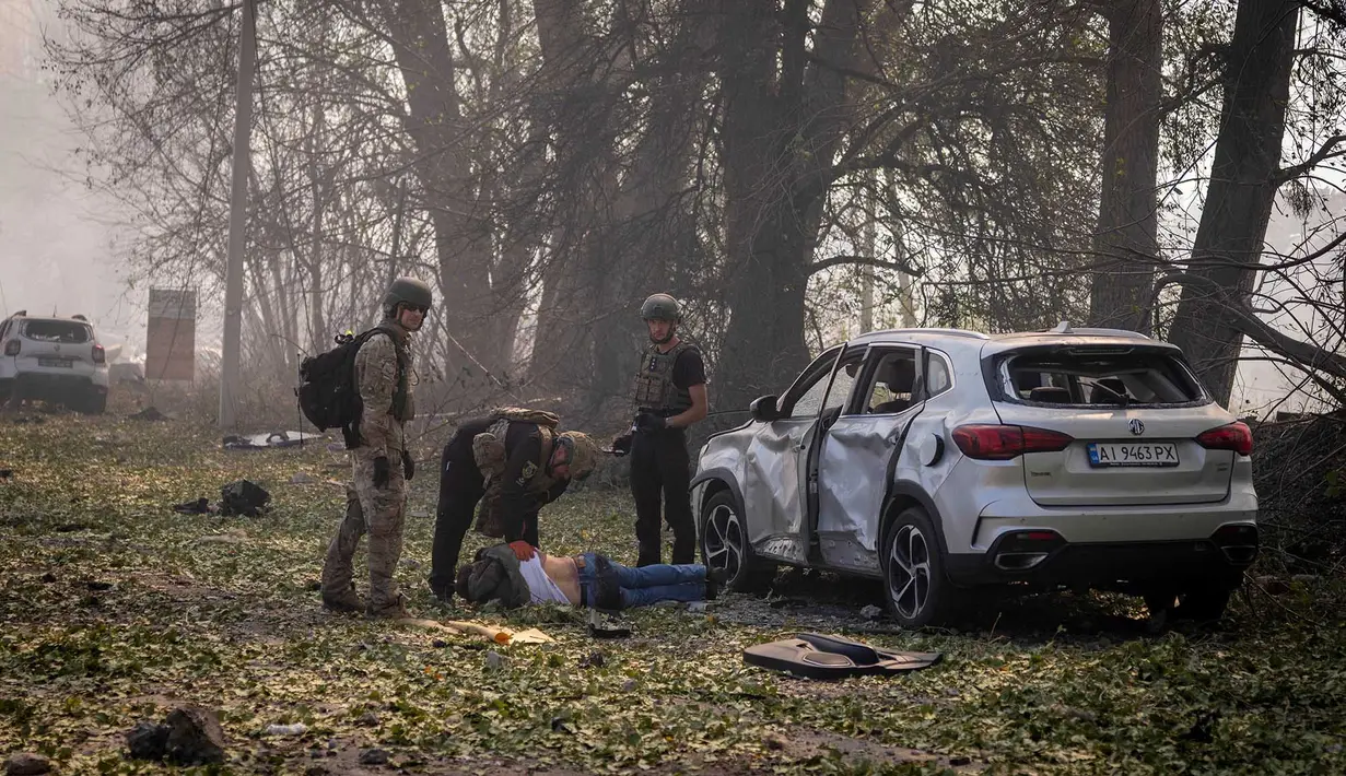 Polisi memeriksa jenazah seorang pengemudi setelah serangan Rusia menghantam sebuah gudang, yang diikuti oleh ledakan, di desa Myla, wilayah Kyiv, Ukraina, Sabtu, 29 Agustus 2026. (Foto AP/Dan Bashakov)