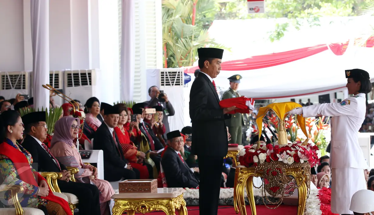 Presiden Joko Widodo menyerahkan Sang Saka Merah Putih kepada petugas pembawa baki Paskibraka Nilam Sukma Pawening saat upacara Peringatan Hari Kemerdekaan ke-71 RI di Istana Merdeka, Jakarta, Rabu (17/8). (Liputan6.com/Faizal Fanani)