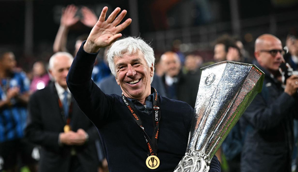 Pelatih Atalanta, Gian Piero Gasperini tersenyum sambil melambaikan tangan saat merayakan gelar juara Liga Europa 2023/2024 setelah mengalahkan Bayer Leverkusen dengan skor 3-0 pada laga final yang berlangsung di Dublin Arena, Irlandia, Kamis (23/05/2024) dini hari WIB. (AFP/Paul Ellis)