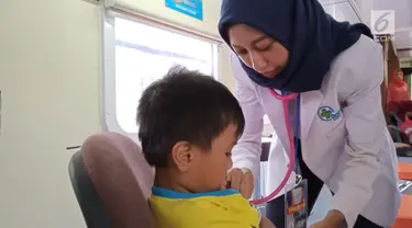 Petugas medis memeriksa seorang anak yang berobat ke Rail Clinic yang berhenti di Stasiun Alastua, Semarang, Jawa Tengah, Kamis ( 28/3). Pengobatan gratis dari PT KAI ini dihadiri oleh ratusan warga sekitar stasiun. (Liputan6.com/Gholib)