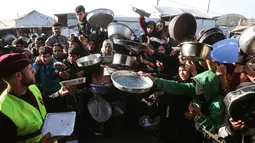 Lonjakan harga pangan yang drastis dan mengancam jutaan warga dengan bencana kelaparan yang berulang. Tampak dalam foto, warga Palestina yang mengungsi berebut untuk makanan di Khan Younis, selatan Jalur Gaza pada Jumat 6 Maret 2026. (Bashar Taleb/AFP)
