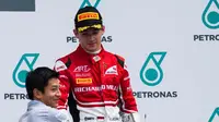 Pebalap Indonesia, Rio Haryanto, menyerahkan trofi kepada development driver Ferrari, Charles Leclerc, yang naik podium ketiga pada balapan pertama GP3 Malaysia di Sirkuit Sepang, Sabtu (1/10/2016). (Rio Haryanto Media) 