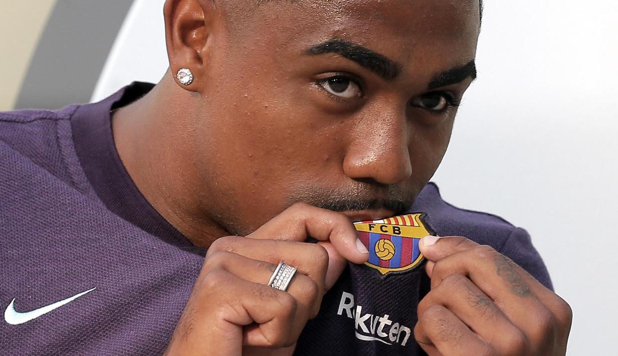 Pemain baru Barcelona, Malcom Filipe Silva de Oliveira, mencium lambang klub saat tiba di Stadion Camp Nou, Barcelona, Selasa (24/7/2018). Blaugrana resmi mendapatkan jasa pemain Bordeaux ini dengan harga 41 juta euro. (AP/Manu Fernandez)