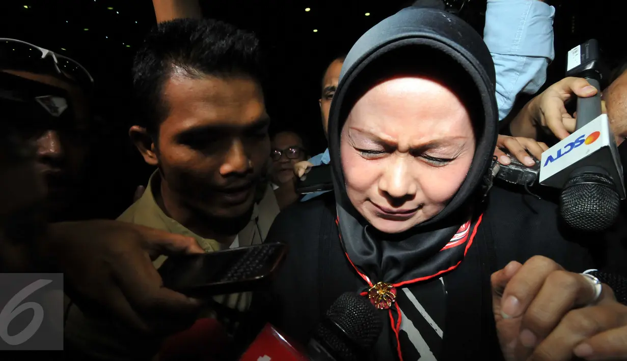 Istri Pelaksana Tugas (Plt) Gubernur Sumatera Utara Tengku Erry Nuradi, Evi Diana, menghindar dari wartawan usai diperiksa KPK, Jakarta, Kamis (5/11/15). Evi yang diperiksa sebagai saksi untuk Gatot Pujo Nugroho. (Liputan6.com/Helmi Afandi) 
