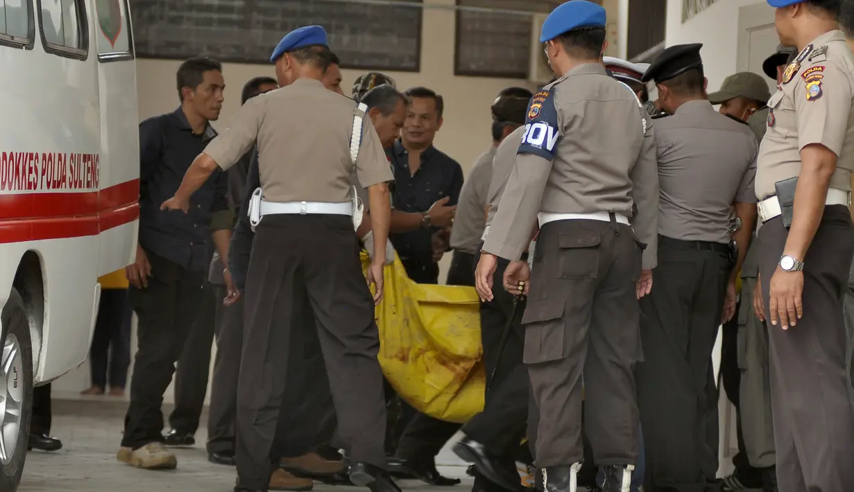 Kantong jenzah dibawa masuk petugas kepolisian ke ruang jenazah di RS Bhayangkara Palu, Sulawesi Tengah, Selasa (17/7). Dua jenazah diduga teroris Santoso alias Abu Warda dan Muhtar yang tewas dalam baku tembak itu akan diidentifikasi. (OLAGONDRONK/AFP)