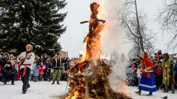 Warga membakar patung Lady Winter yang terbuat dari jerami, kayu dan kain saat perayaan Shrovetide di kota Vsevolozhsk, Rusia (18/2). Perayaan ini menandai berakhirnya musim dingin yang dirayakan sejak masa pagan. (AP Photo / Olga Maltseva)