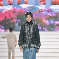 Aurel Hermansyah tampil dengan brand Shi by Shireen Sungkar. Ia mengenakan atasan kemeja hitam bercorak bunga lengan panjang pump dipadukan kerudung warna senada serta bondu beads. Ia memilih skirt panjang baby blue dengan aksen bulu-bulu. [@aurelie.hermansyah]