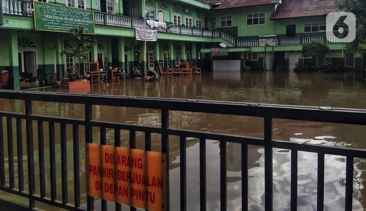 Banjir menggenangi sekolah di Kebalen, Jakarta, Minggu (21/2/2021). Banjir yang terjadi kemarin karena curah hujan yang tinggi meninggalkan sampah di rumah warga. (Liputan6.com/Johan Tallo)