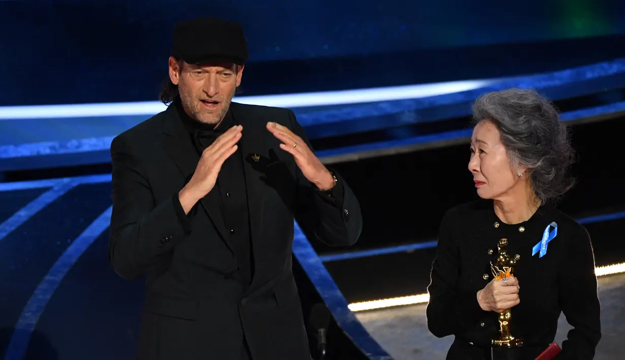 Troy Kotsur (kiri) menerima penghargaan dalam kategori pendukung terbaik di atas panggung Academy Award ke-94 di Dolby Theatre di Hollywood, California, Minggu (27/3/2022). Troy Kotsur berhasil cetak sejarah menjadi aktor tuli pertama yang memenangkan Oscar. (Robyn Beck/AFP)