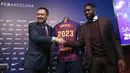 Bek Prancis, Samuel Umtiti dan Presiden Barcelona Josep Maria Bartomeu bersalaman pada pengumuman perpanjangan kontraknya di Camp Nou, Senin (4/6). Umtiti mendapatkan kontrak baru, yang akan mengikatnya di Camp Nou hingga 2023. (AP/Manu Fernandez)