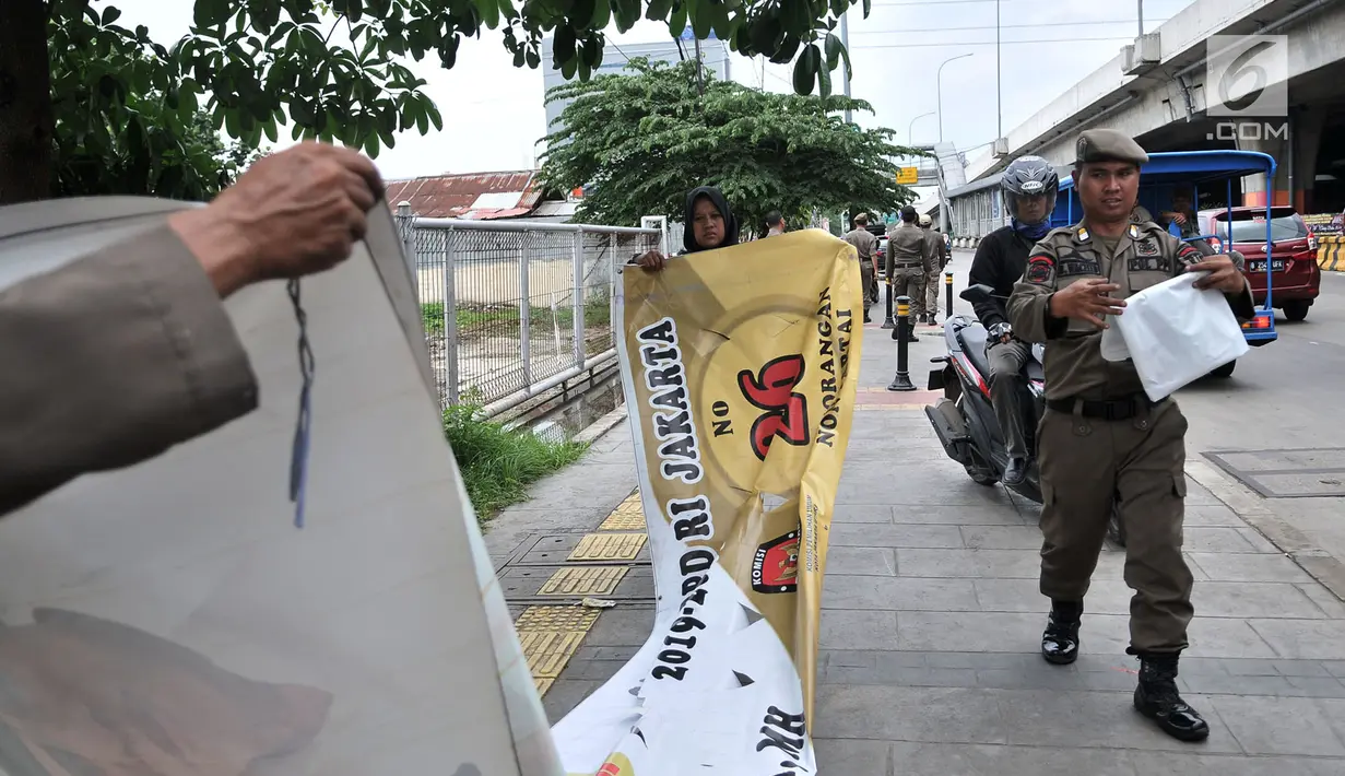 <p>Petugas Satpol PP menertibkan Alat Peraga Kampanye (APK) di sepanjang Jalan Yos Sudarso, Jakarta Utara, Rabu (13/3). APK yang dipasang di sembarang tempat dan fasilitas umum melanggar SK KPU nomor 175. (merdeka.com/Iqbal S. Nugroho)</p>