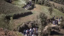 Orang-orang berjalan menuruni bukit saat mereka menghadiri pemakaman Rayan Oram (5) di Desa Ighran, Provinsi Chefchaouen, Maroko, 7 Februari 2022. Rayan Oram meninggal setelah terjebak selama lima hari dalam sumur kering sedalam 32 meter. (AP Photo/Mosa'ab Elshamy)