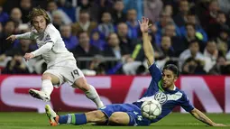 Pemain Real Madrid, Luka Modric, dihadang pemain Wolfsburg, Ricardo Rodriguez pada leg kedua perempat final Liga Champions di Stadion Santiago Bernabeu, Madrid, Rabu (13/4/2016) dini hari WIB. (AFP/Javier Soriano)