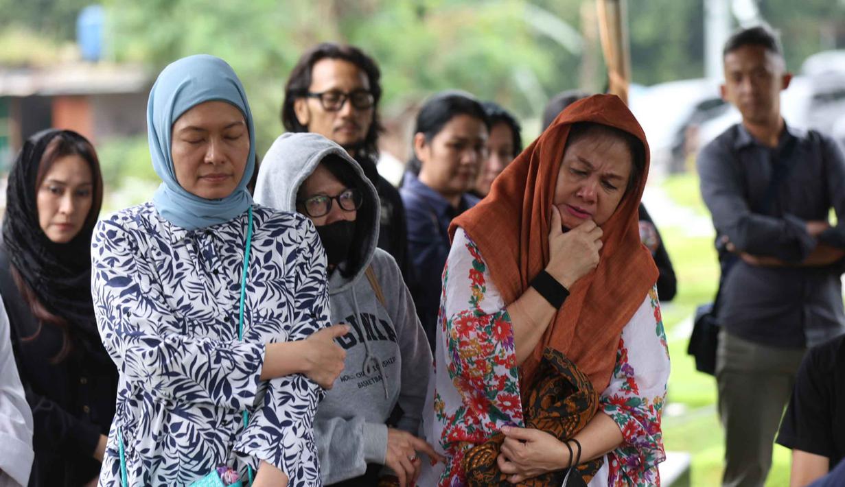 Isak tangis dan doa mengiringi kepergian sosok yang dikenal rendah hati namun sangat berpengaruh dalam sejarah musik nasional tersebut. Tampak dalam foto, beberapa kerabat dan keluarga menyaksikan prosesi pemakaman jenazah Donny Fattah di Tempat Pemakaman Umum (TPU) Kampung Kandang, Jagakarsa, Jakarta Selatan, Sabtu (7/3/2026). (Kapanlagi.com/Budy Santoso)