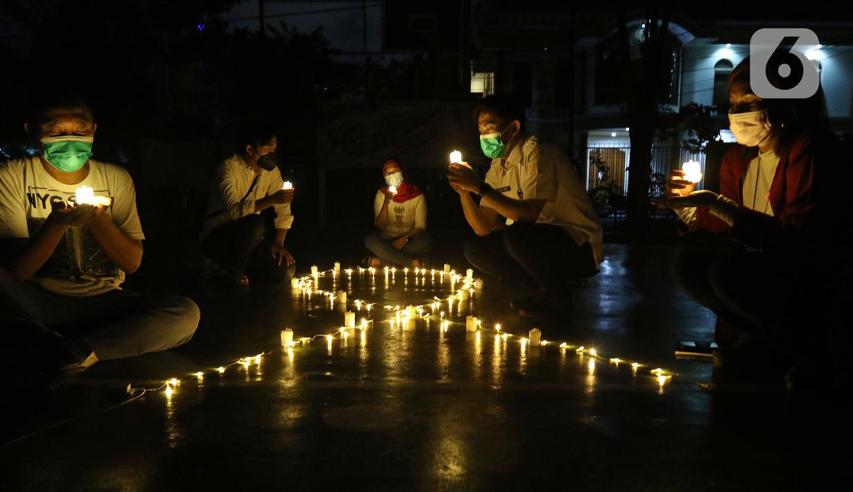 Sejumlah relawan menyalakan lampu pada malam renungan Hari AIDS Sedunia di Tanah Abang, Jakarta, Rabu (1/12/2021). Acara ini digelar secara gabungan oleh lembaga dan relawan pendamping orang dengan HIV/AIDS (ODHA). (Liputan6.com/Herman Zakharia)