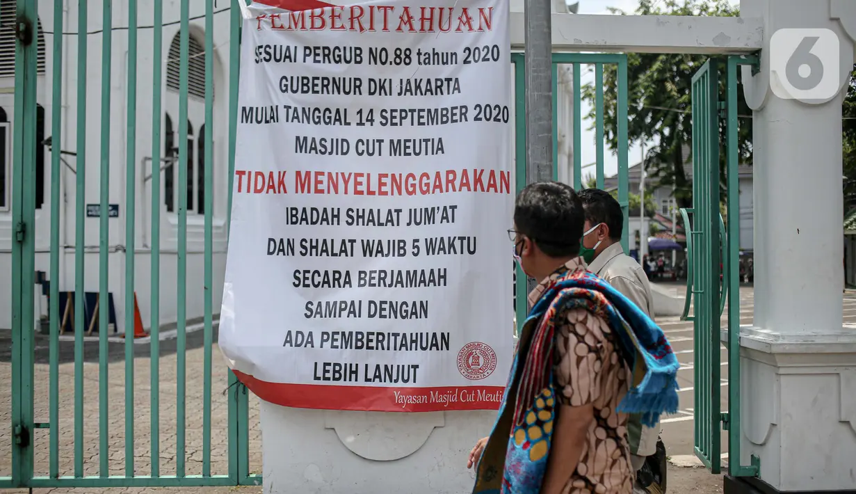 Warga melihat spanduk pemberitahuan yang terpampang di Masjid Cut Meutia, Jakarta, Jumat (18/9/2020). Pemprov DKI Jakarta kembali meniadakan kegiatan ibadah salat Jumat dan salat lima waktu berjemaah di semua Masjid Raya selama PSBB. (Liputan6.com/Faizal Fanani)