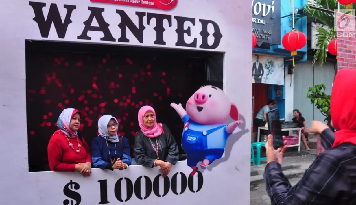 Warga foto bersama saat menikmati kemeriahan Pasar Imlek Semawis 2570 di kawasan Pecinan Semarang, Jawa Tengah, Sabtu (2/1). Pada tahun Babi Tanah ini Pasar Semawis mengusung tema 'Warga Rukun Agawe Santoso'. (Liputan6.com/Gholib)