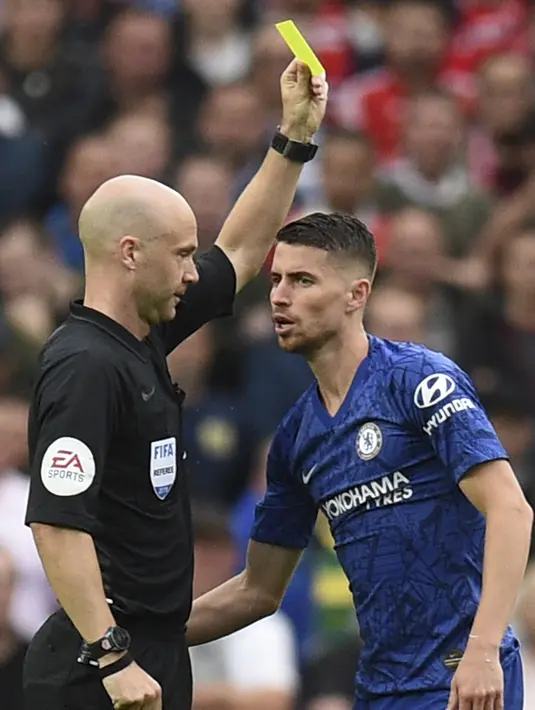 Wasit Anthony Taylor memberikan kartu kuning ke gelandang Chelsea, Jorginho selama bertanding melawan Manchester United pada Liga Inggris di Old Trafford (11/8/2019). MU menang telak 4-0 atas Chelsea. (AFP Photo/Oli Scarff)