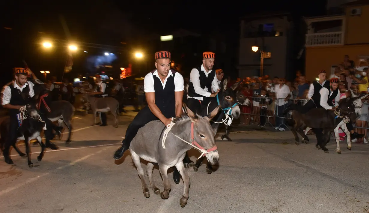 Para peserta berpartisipasi dalam kompetisi balap keledai tradisional ke-53 di Tribunj, Kroasia  (29/8/2020). (Xinhua/Pixsell/Hrvoje Jelavic)