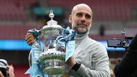 Manajer Manchester City, Pep Guardiola, berpose dengan trofi di lapangan setelah pertandingan final Piala FA Inggris antara Chelsea melawan Manchester City di Stadion Wembley, London, pada 16 Mei 2026. City memenangkan pertandingan dengan skor 1-0. Gelar FA Cup ketiga pada era kepelatihan Guardiola tersebut mengakhiri rentetan dua kekalahan beruntun City di partai final. (Adrian Dennis / AFP)