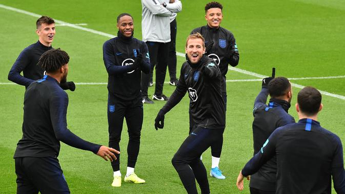 Striker Inggris Harry Kane (tengah) tertawa saat mengikuti sesi pelatihan tim  di Staplewood Campus di southampton, Inggris selatan (9/9/2019). Inggris akan bertanding melawan Kosovo pada grup A Kualifikasi Euro 2020 di Stadion Saint Mary. (AFP Photo/Glyn Kirk)