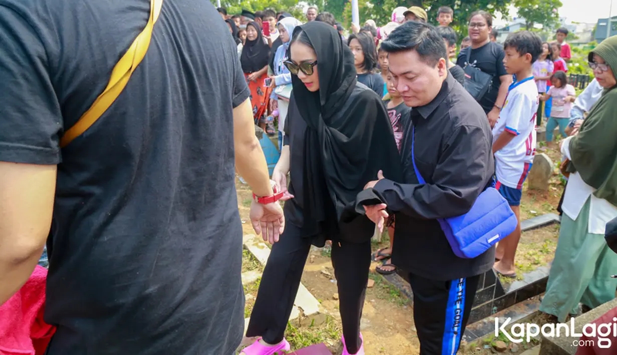 Sekitar pukul 14.00 WIB, Nagita bersama Wanda Hara dan Merry Ahmad tiba di pemakaman. Kehadiran istri Raffi Ahmad itu menjadi pusat perhatian warga setempat. [Foto: KapanLagi.com®/Muhammad Akrom Sukarya]