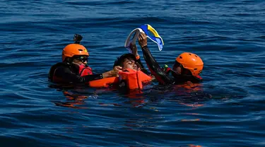 Anggota Badan Pencarian dan Pertolongan Nasional (Basarnas) menyelamatkan seorang relawan saat latihan bersama di perairan lepas pantai Banda Aceh pada 31 Agustus 2024. (CHAIDEER MAHYUDDIN/AFP)