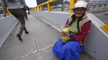 Alejandra Baldani, nenek 78 tahun, menjual permen di sebuah jembatan penyeberangan di distrik San Borja, Lima, 22 Oktober 2015. Nenek Baldani mendapatkan sekitar USD 3 per hari dari hasil berjualan permen. (REUTERS / Mariana Bazo)