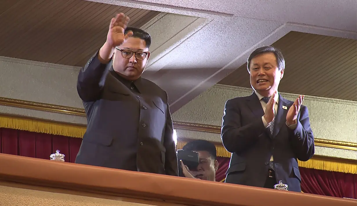 Pemimpin Korea Utara Kim Jong-Un (kiri) menyapa hadirin yang datang saat konser yang menampilkan sejumlah musisi dari Korea Selatan di East Pyongyang Grand Theatre, Korea Utara (4/1). (AFP Photo/Korea Pool)