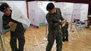 Tentara Korea Selatan (Korsel)  keluar dari bilik suara di sebuah TPS di Seoul, Kamis (4/5). Selama 2 hari, masyarakat yang terdaftar sebagai pemilih dapat memberikan suara sebelum pemilihan presiden (Pilpres) pada 9 Mei mendatang. (JUNG Yeon-Je/AFP)