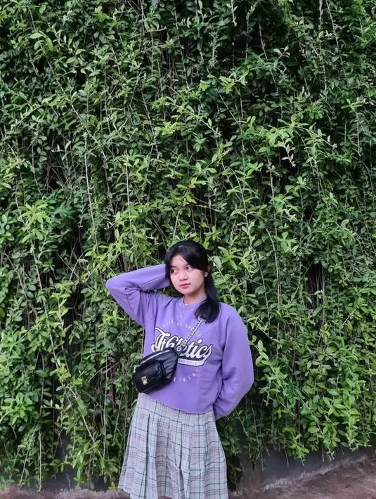 Tak jarang ia tampil feminin memakai sweater ungu dipadukan dengan mini skirt warna senada dan selling bag. @amaninaafiqah.