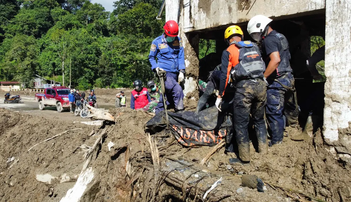 Badan Nasional Penanggulangan Bencana (BNPB) menegaskan bahwa seluruh unsur pemerintah daerah, TNI–Polri, Basarnas, kementerian/lembaga, serta relawan terus mengerahkan sumber daya untuk mempercepat pencarian korban. Tampak dalam foto, tim penyelamat mengevakuasi jenazah korban banjir di Padang Panjang, Sumatera Barat, Senin 1 Desember 2025. (AP Photo/Ali Nayaka)