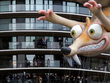 Balon animasi film Ice Age, Tupai Scrat melayang di dekat teras bangunan selama parade tahunan Macy's Thanksgiving Day ke-90 di Manhattan, New York, Kamis (24/11). Parade ini pertama kali diadakan oleh Macy's pada 1924 di New York. (REUTERS/Andrew Kelly)