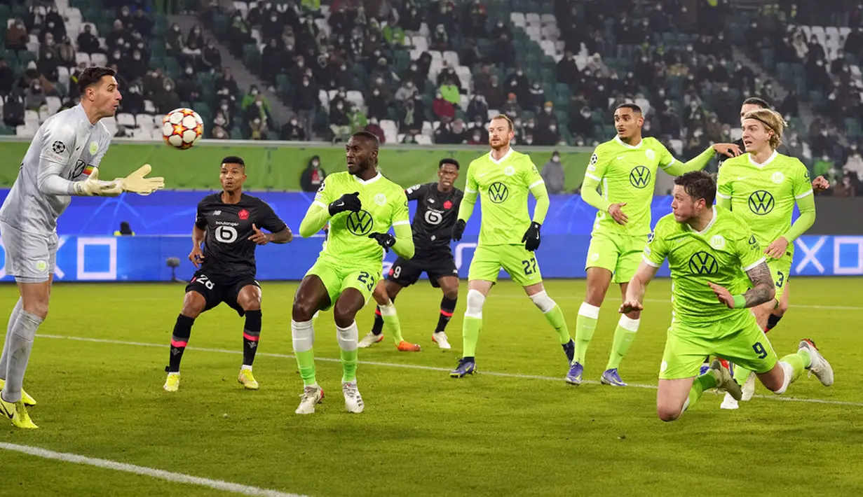 Penjaga gawang Wolfsburg Koen Casteels (kiri) menangkap bola saat melawan Lille pada pertandingan sepak bola Grup G Liga Champions di Wolfsburg, Jerman, 8 Desember 2021. Lille menang 3-1. (AP Photo/Martin Meissner)