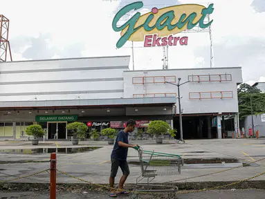 Pengunjung melintas di depan Supermarket Giant Ekstra di Kreo, Tangerang, Senin (2/8/2021). PT Hero Supermarket Tbk resmi menutup seluruh gerai Giant di Indonesia pada Minggu (1/8/2021), dan akan lebih fokus pada pengembangan gerai merek lainnya. (Liputam6.com/Faizal Fanani)