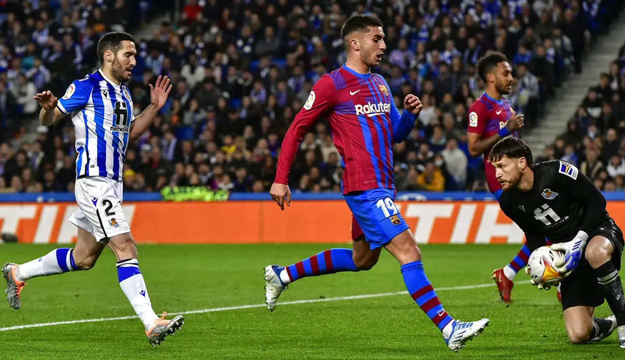 <p>Penjaga gawang Real Sociedad Alex Remiro (kanan) menyelamatkan bola saat melawan Barcelona pada pertandingan Liga Spanyol di Reale Arena Stadium, San Sebastian, Spanyol, 21 April 2022. Barcelona menang 1-0. (AP Photo/Alvaro Barrientos)</p>