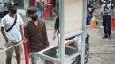 Pengunjung mencuci tangan saat masuk ke kawasan Pasar Minggu, Jakarta, Selasa (23/6/2020). Pascapenutupan tiga hari terkait ditemukannya tiga pedagang yang positif COVID-19, pengunjung Pasar Minggu kini diwajibkan mencuci tangan dan cek suhu tubuh. (Liputan6.com/Immanuel Antonius)