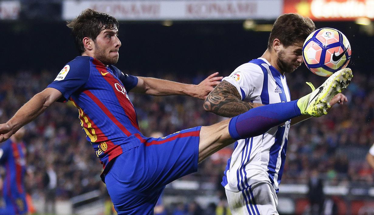 Pemain Barcelona, Sergi Roberto (kiri) berduel dengan pemain kiper Real Sociedad, Inigo Martínez pada lanjutan La Liga di Camp Nou stadium in Barcelona, Spanyol, (15/4/2017). Barcelona menang 3-2.  (AP /Manu Fernandez)