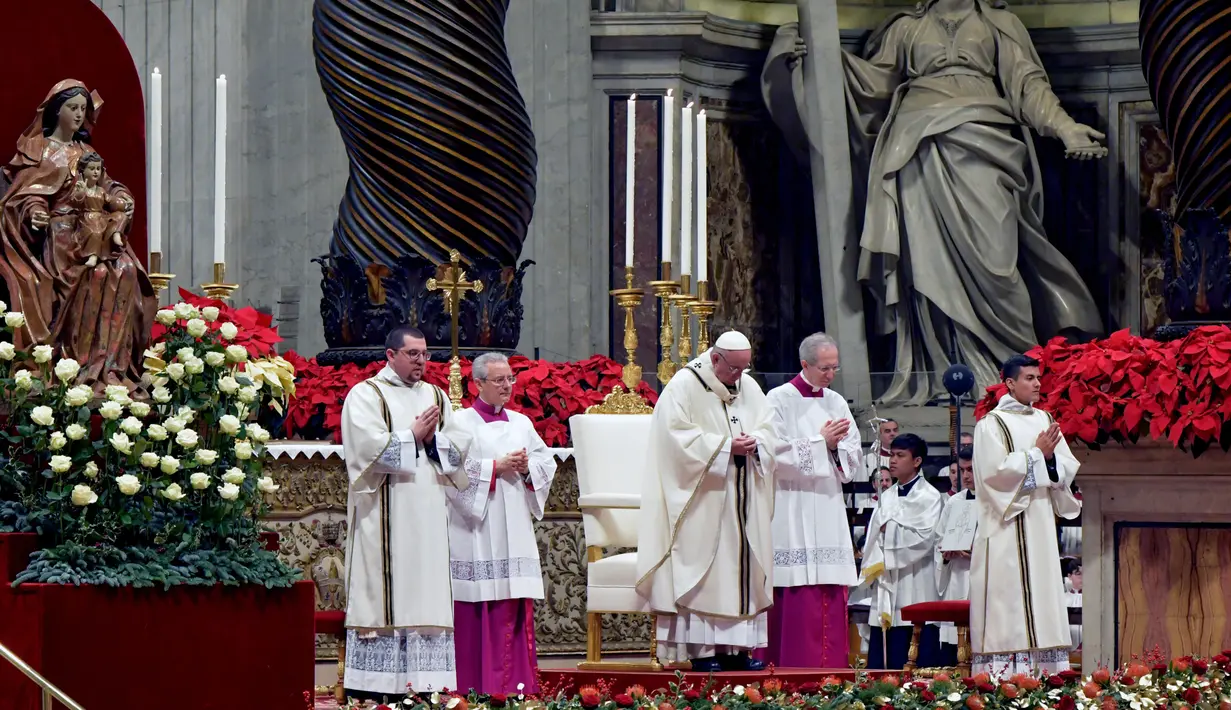 Suasana misa Natal di Basilika Santo Petrus, Vatikan, (24/12). Paus Fransiskus menyerukan kepada masyarakat di negara maju agar menjalani kehidupan yang sederhana dan tidak terlalu materialistis. (AFP Photo/Tiziana Fabi)