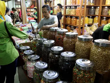 Pedagang melayani pembeli kue kering di Pasar Mayestik, Jakarta Selatan, Senin (11/6). Separuh Ramadan dan jelang lebaran masyarakat mulai berburu kue kering. (Liputan6.com/Johan Tallo)