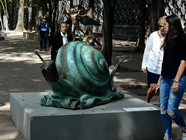 Pengunjung melihat patung "Snail dan Angel" saat pameran "Salvador Dali: Urban Dreams" di Mexico City, Selasa (14/3). Patung-patung tersebut adalah karya seniman asal spanyol yang bernama Salvador Dali. (AFP PHOTO / RONALDO SCHEMIDT)