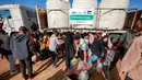 Warga mengisi wadah air dari tangki air portabel di kamp pengungsi Palestina Maghazi, Jalur Gaza tengah pada Rabu 11 Februari 2026. Warga Palestina di Jalur Gaza masih menghadapi kekurangan pasokan air bersih. (Eyad BABA/AFP)