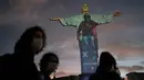 Patung Christ the Redeemer diterangi dengan gambar sebagai penghormatan kepada orang-orang yang telah meninggal karena COVID-19, di Rio de Janeiro, Brasil, Rabu (1/7/2020). Covid-19 telah menewaskan sedikitnya 512.383 orang sejak pandemi itu muncul di China Desember 2019 lalu. (AP/Leo Correa)