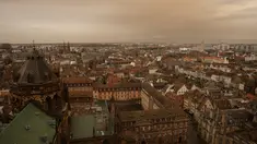 Pemandangan kota Strasbourg tampak diselimuti debu Sahara berwarna oranye bergerak di atas kota di Prancis timur (15/3/2022). Badai di gurun Sahara menciptakan badai besar hembusan angin, yang mengangkat pasir ke udara. (AP Photo/Jean-Francois Badias)