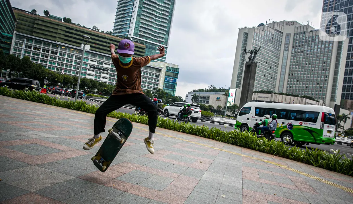 Aksi warga saat bermain skateboard di trotoar Jalan Sudirman-Thamrin, Jakarta, Jumat (5/3/2021). Gubernur DKI Jakarta Anies Baswedan mengizinkan trotoar untuk digunakan sebagai tempat bermain skateboard dengan beberapa kesepakatan. (Liputan6.com/Faizal Fanani)