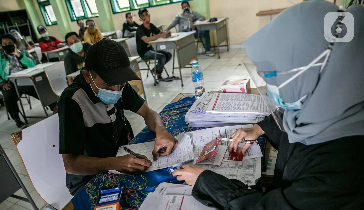 Warga mengisi data saat mengambil Bantuan Sosial Tunai (BST) di SMAN 111, Jakarta, Selasa (19/1/2021). Pemprov DKI Jakarta menyalurkan BST sebesar Rp 300 ribu kepada 1.055.216 KK mulai Januari hingga April 2021. (Liputan6.com/Faizal Fanani)