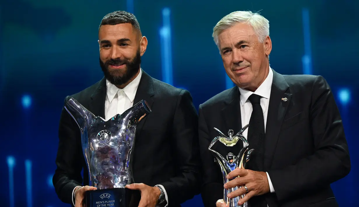 Penyerang Real Madrid, Karim Benzema bersama pelatihnya Carlo Ancelotti berpose dengan penghargaan Pemain dan Pelatih Terbaik Eropa 2021-2022 dalam upacara pengundian Liga Champions di Istanbul, Turki, Kamis (25/8/2022). (AFP/Ozan Kose)